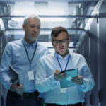 dois homens dentro de data center com tablet